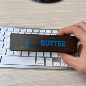 Brown butter-style slow rebound squishy stress relief toy being held over a keyboard