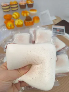 Detailed close-up of super soft slow-rebound butter toast squishy being squeezed by hand