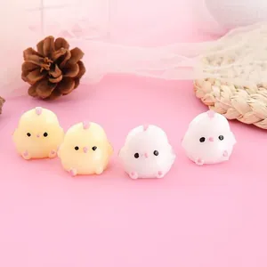 Primer plano de cuatro lindos juguetes squishy de pollitos amarillos y blancos sobre fondo rosa