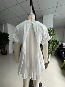 Detailed view of women's white short sleeve top with elegant pleated back design