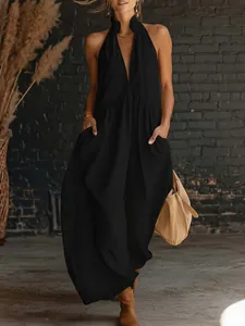Detail view of a black sleeveless halter maxi dress with functional side pockets.