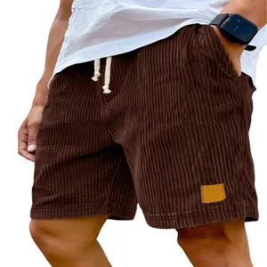 Detailweergave van de bruine corduroy herenshort met trekkoord en een logo-patch