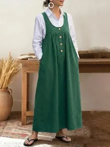 Full length view of a green sleeveless button-front pinafore dress with loose casual fit