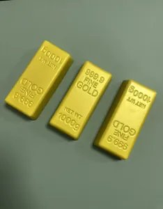 Detailed macro view of three gold bar shaped squishy toys with fine gold engraving