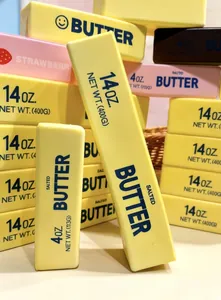 Detailansicht eines gelben Butter-Squishy-Spielzeugs mit realistischen Aufdrucken.