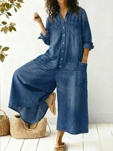 Close-up detail of a loose-fit blue denim jumpsuit featuring single-breasted buttons