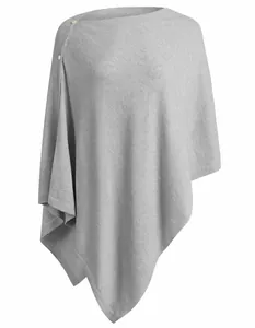 Close-up of grey knit shawl detail showcasing button closure and soft wool-like texture