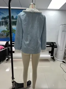 Vue arrière détaillée d'un chemisier bleu clair à broderie florale sur mannequin