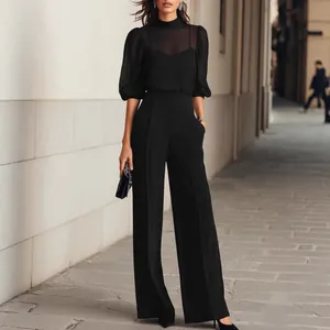 Elegant black two-piece set featuring sheer puff sleeve top and high-waisted trousers