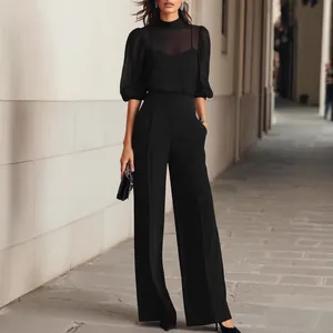 Elegant black women's set with sheer mesh top and high-waisted wide-leg trousers for office.