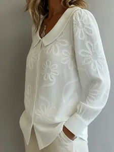 Gros plan détaillé d'une chemise blanche à manches longues avec jacquard floral et col claudine