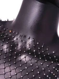 Detailed macro view of black fishnet mesh top featuring sparkling silver rhinestones