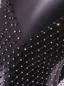 Detail of black fishnet mesh top with sparkling crystal rhinestones for women