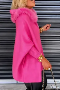 Detailaufnahme von pinkfarbener Oversize-Strickjacke mit Kapuze und Pelzkragen.
