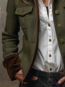 Close-up detail of green herringbone tweed blazer with brown velvet sleeve cuffs.