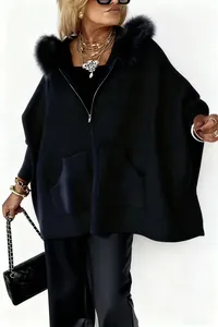 Detailaufnahme der schwarzen Strickjacke mit Kapuze und großem Kunstfellkragen.