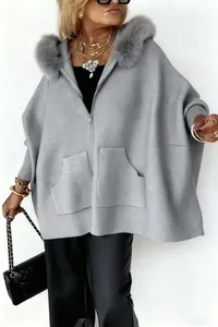 Übergroße graue Strickjacke mit Kapuze, Kunstpelzkragen und Reißverschlusstaschen am Model.