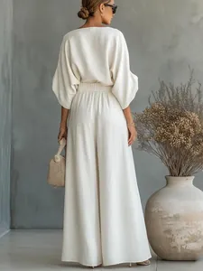 Vista posteriore di un elegante completo bianco due pezzi con pantaloni ampi e top morbido