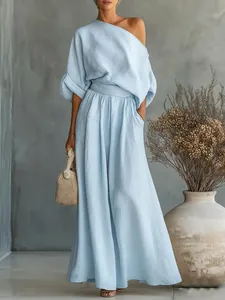Vista completa di un elegante completo azzurro con top a spalla scoperta e pantaloni.