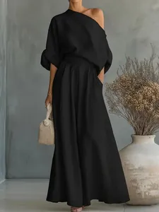 Elegante completo a due pezzi con top nero a una spalla e pantaloni a gamba larga abbinati