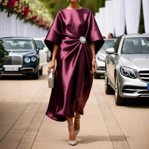 Elegante vestido midi de satén color ciruela con broche de flor de cristal para ocasiones.