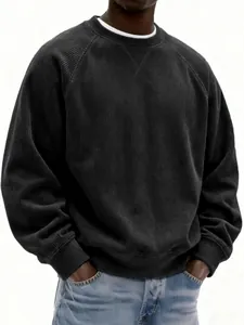 Close-up of black corduroy sweatshirt featuring ribbed texture and round neck detail.