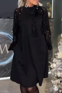 Elegante abito corto nero con maniche lunghe di paillettes e raffinato fiocco allo scollo