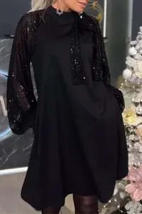 Dettaglio di mini abito nero con maniche a palloncino di paillettes e fiocco