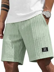 Detailansicht der Herren Shorts in Salbeigrün mit Zopfmuster und einem Logo-Aufnäher.