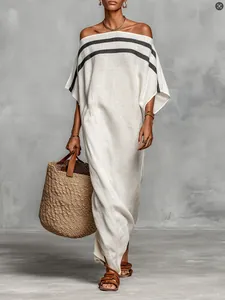 Eleganter Leinen-Kaftan off-shoulder mit schwarzen Streifen und Strohtaschen-Styling.