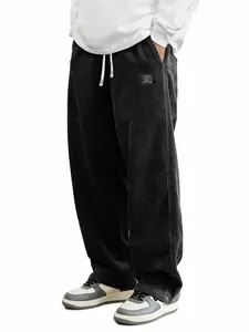 Détail d'un pantalon décontracté en velours côtelé noir pour homme, texture et coupe.