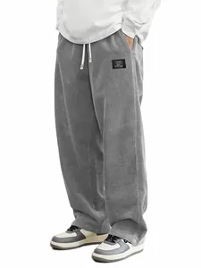 Gros plan d'un pantalon en velours côtelé gris avec cordon et étiquette