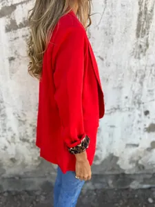 Detalle lateral de una americana roja con forro de estampado de leopardo en los puños