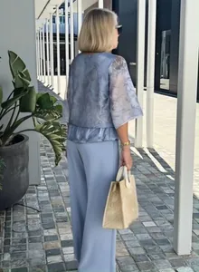 Back view of an elegant blue chiffon printed set with wide-leg pants in an outdoor setting.
