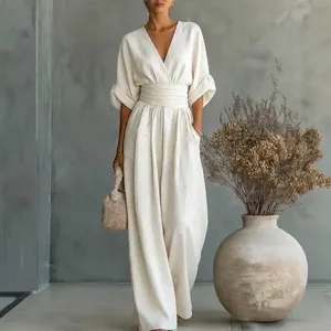 Combinaison blanche élégante à col en V, taille cintrée et jambes larges pour femmes.