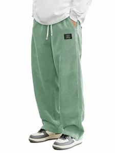 Gros plan sur un pantalon en velours côtelé vert sauge pour homme avec cordon de serrage.