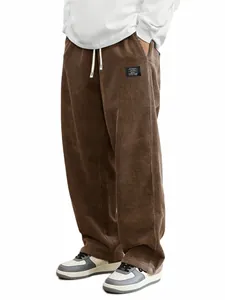 Détail de la texture d'un pantalon en velours côtelé marron pour homme avec cordon.