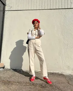 Street style μοντέλο με κρεμ κοντομάνικη ολόσωμη φόρμα με φερμουάρ και κόκκινο μπερέ