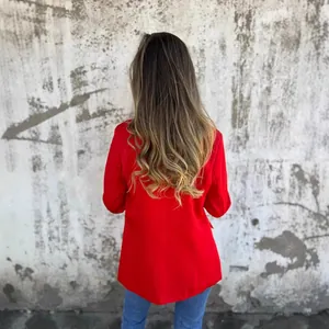 Elegante chaqueta blazer roja para mujer, vista trasera contra una pared texturizada.