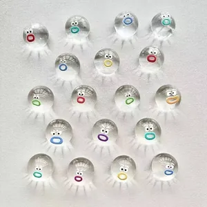 Sammlung von mini transparenten Squishy-Spielzeugen mit bunten Comic-Gesichtern auf weißem Grund
