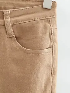 Dettaglio della vita alta e della tasca anteriore di un jeans in denim kaki elasticizzato