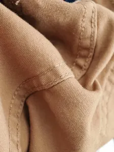 Dettaglio macro del tessuto denim stretch marrone vintage con cuciture di alta qualità