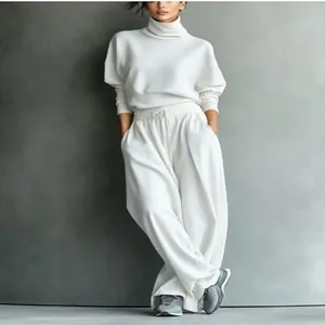 Detalle de conjunto de suéter blanco de cuello alto y pantalones anchos para mujer