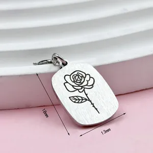 Close-up of laser engraved stainless steel rose birth flower pendant measuring 18mm by 13mm