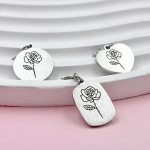 Detail van laser-gegraveerde roestvrijstalen hangers met rozenpatronen op roze achtergrond