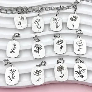 Close-up of twelve laser-engraved stainless steel birth flower pendants in silver