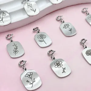 Detailed view of stainless steel pendants with laser-engraved flower patterns
