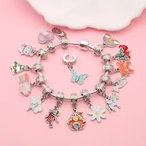 Nahaufnahme eines silbernen DIY-Armbands mit bunten Emaille-Anhängern für Weihnachten.