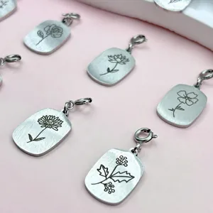 Close-up of laser-engraved stainless steel birth flower charms with lobster clasps