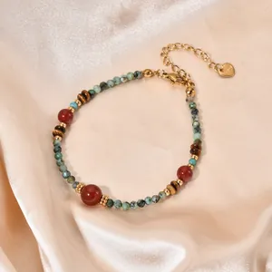Close-up view of a handmade natural stone beaded bracelet with elegant gold-tone chain.